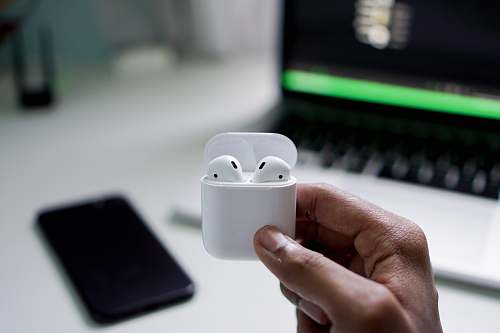 mobile phone person holding wireless earbuds with charging case phone